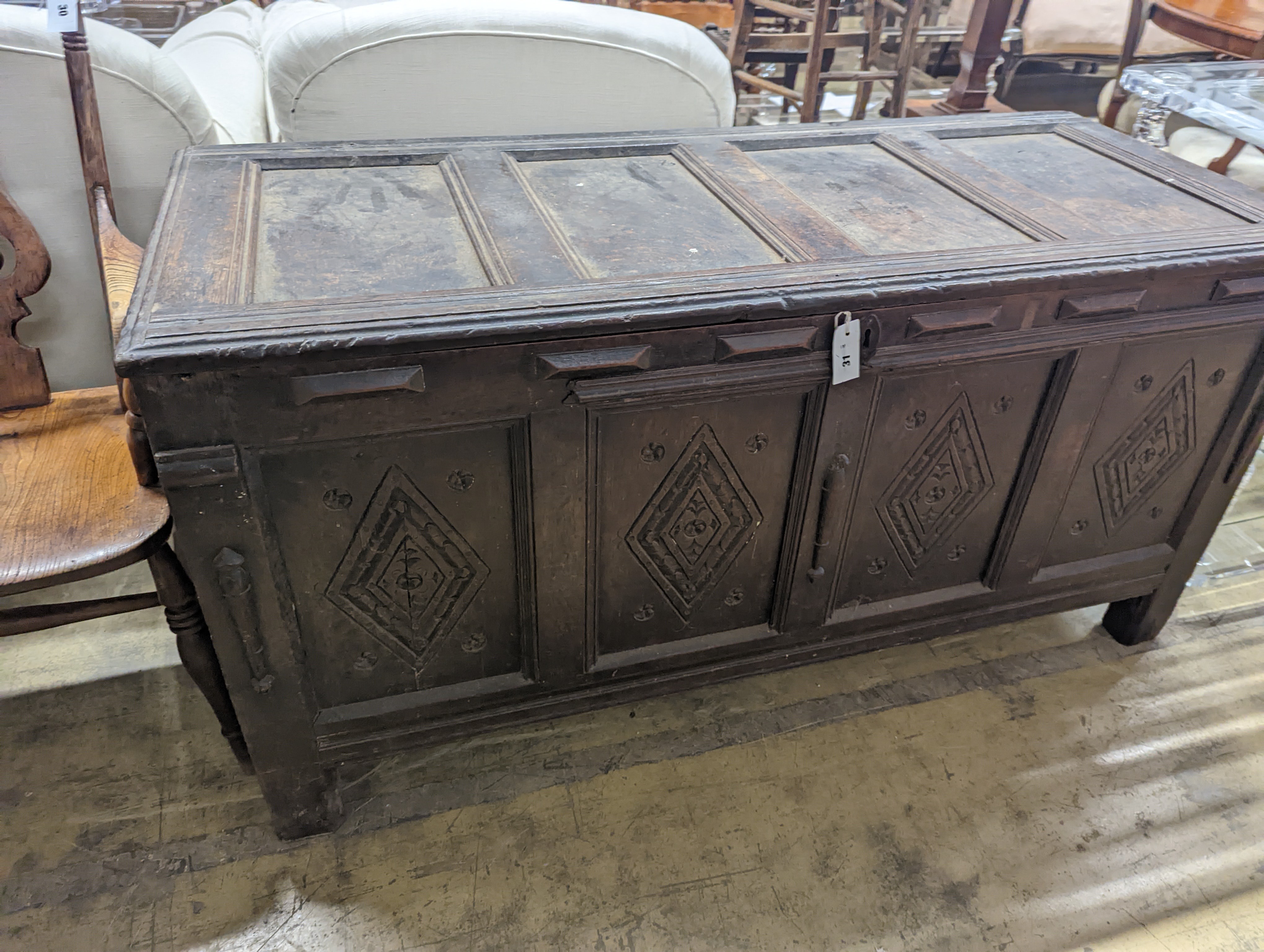 An early 18th century oak coffer, with four panel top and later carved and applied decoration, length 151cm, depth 63cm, height 76cm